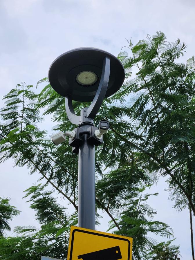 Dua kamera CCTV terpasang pada tiang lampu taman di kawasan hunian