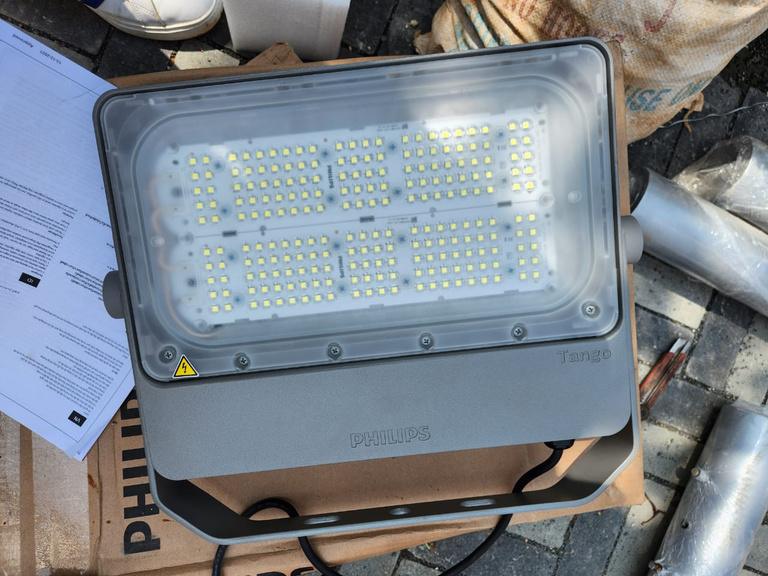 Lampu sorot LED beserta dokumen dan tiang sebelum dipasang