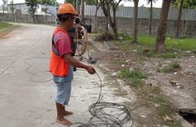 Pekerja menarik kabel pada jalur subduct di jalan kawasan